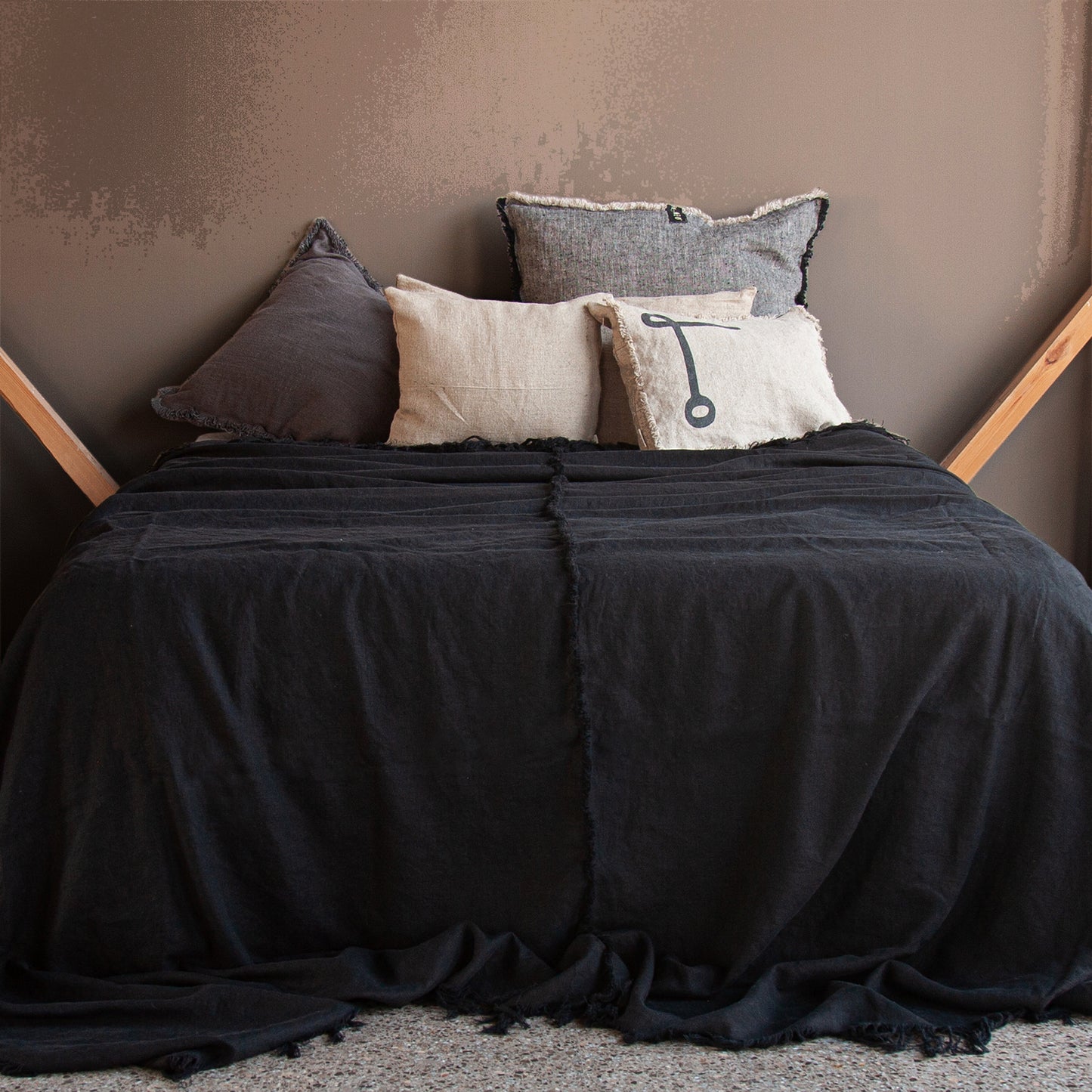 Colcha de lino de color negro con cojines naturales