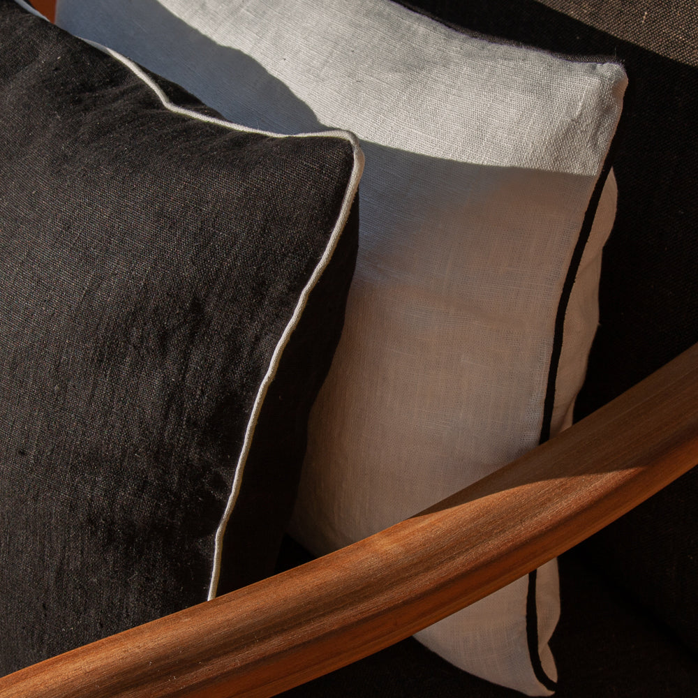 Detalle del acabado ribeteado de cojines de lino blanco y negro.