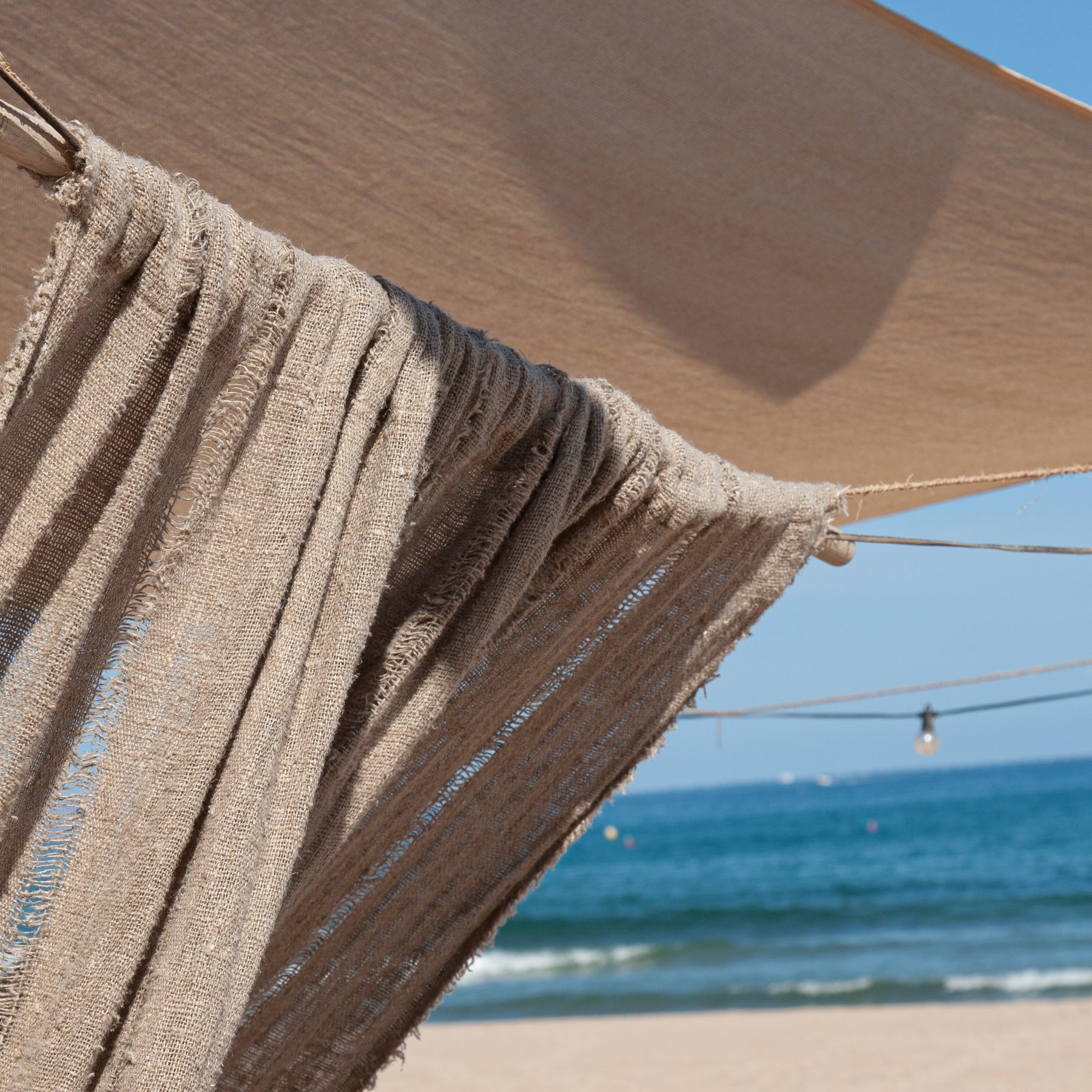 Cortina de lino natural con fondo de mar.