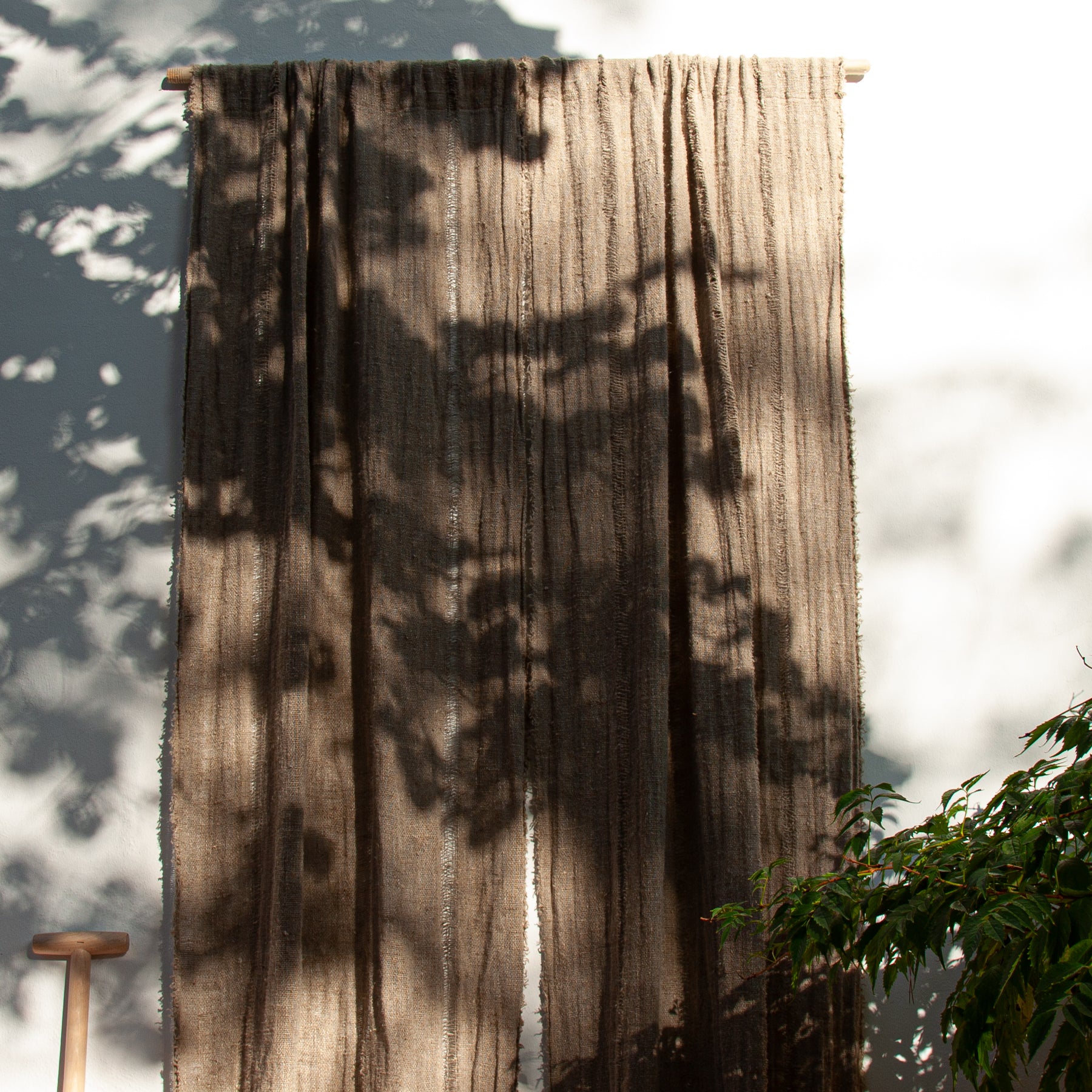 Cortina de lino natural rústico en una pared blanca.