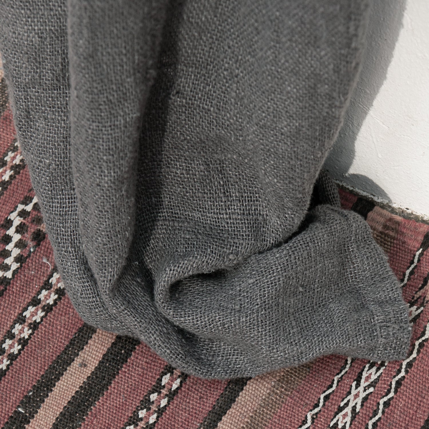 Detalle de cortina gris de lino rústico.