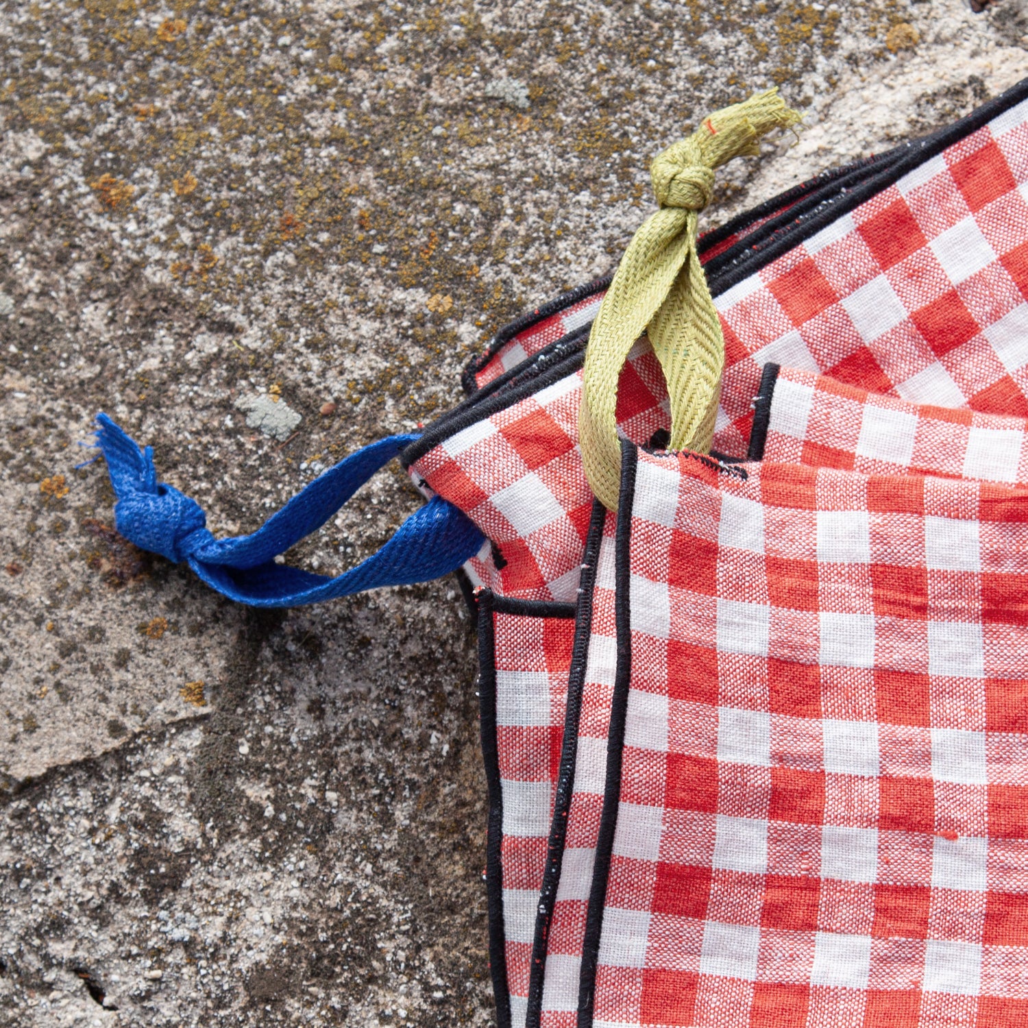 Detalle de colgadores de lino de colores en vichy rojo.