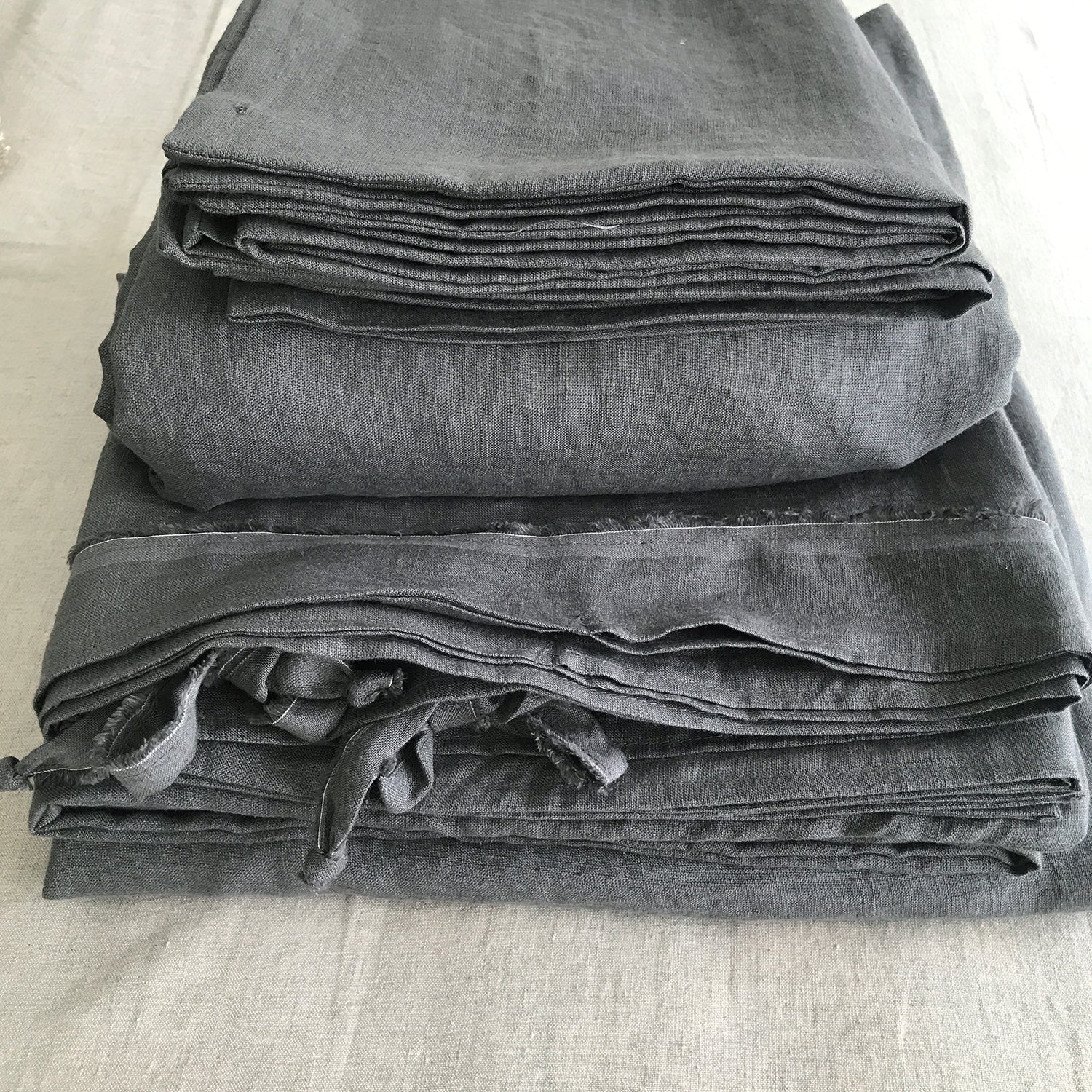 Juego de cama de lino gris con acabado desflecado.