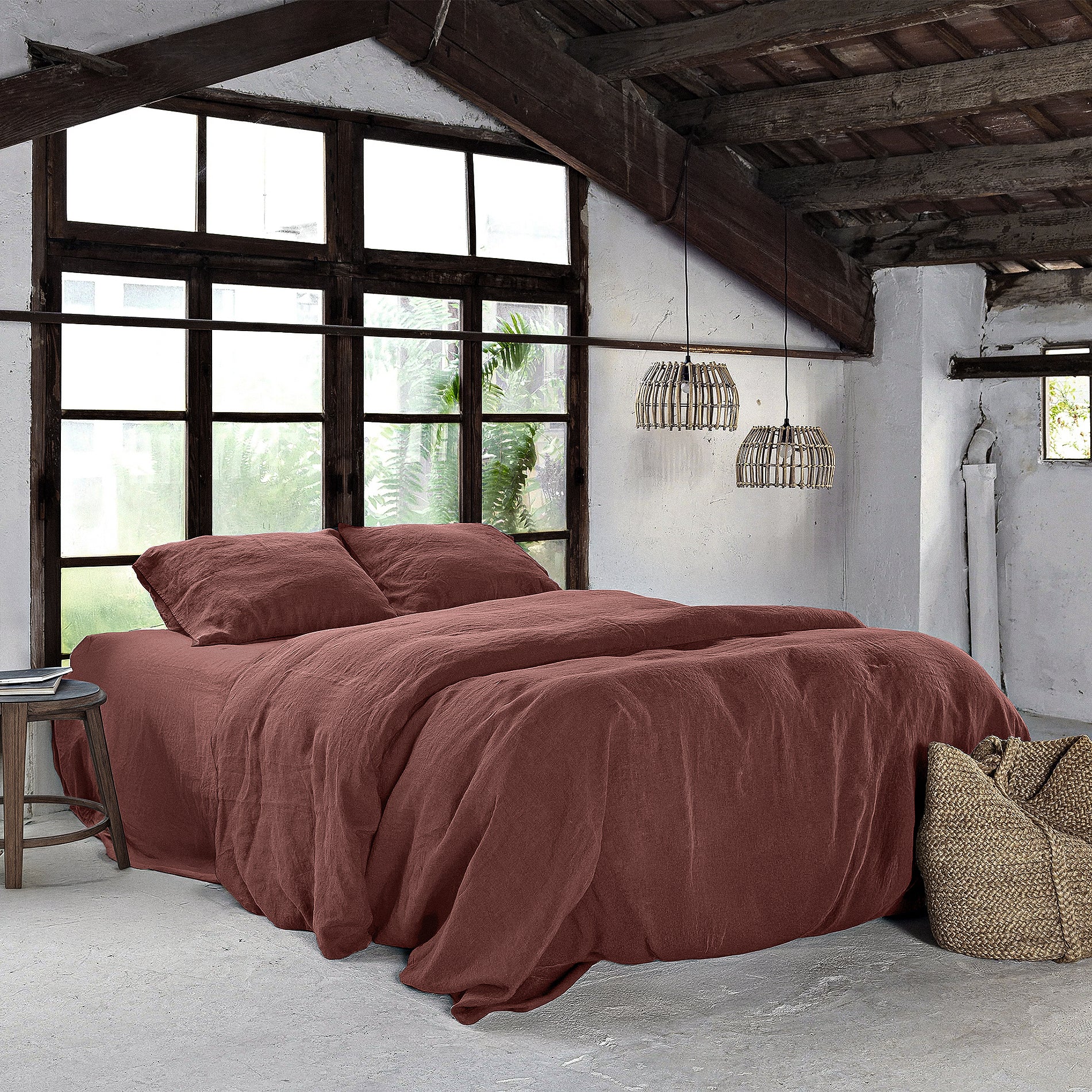 Juego de cama de lino de color burdeos en habitación de estilo rústico