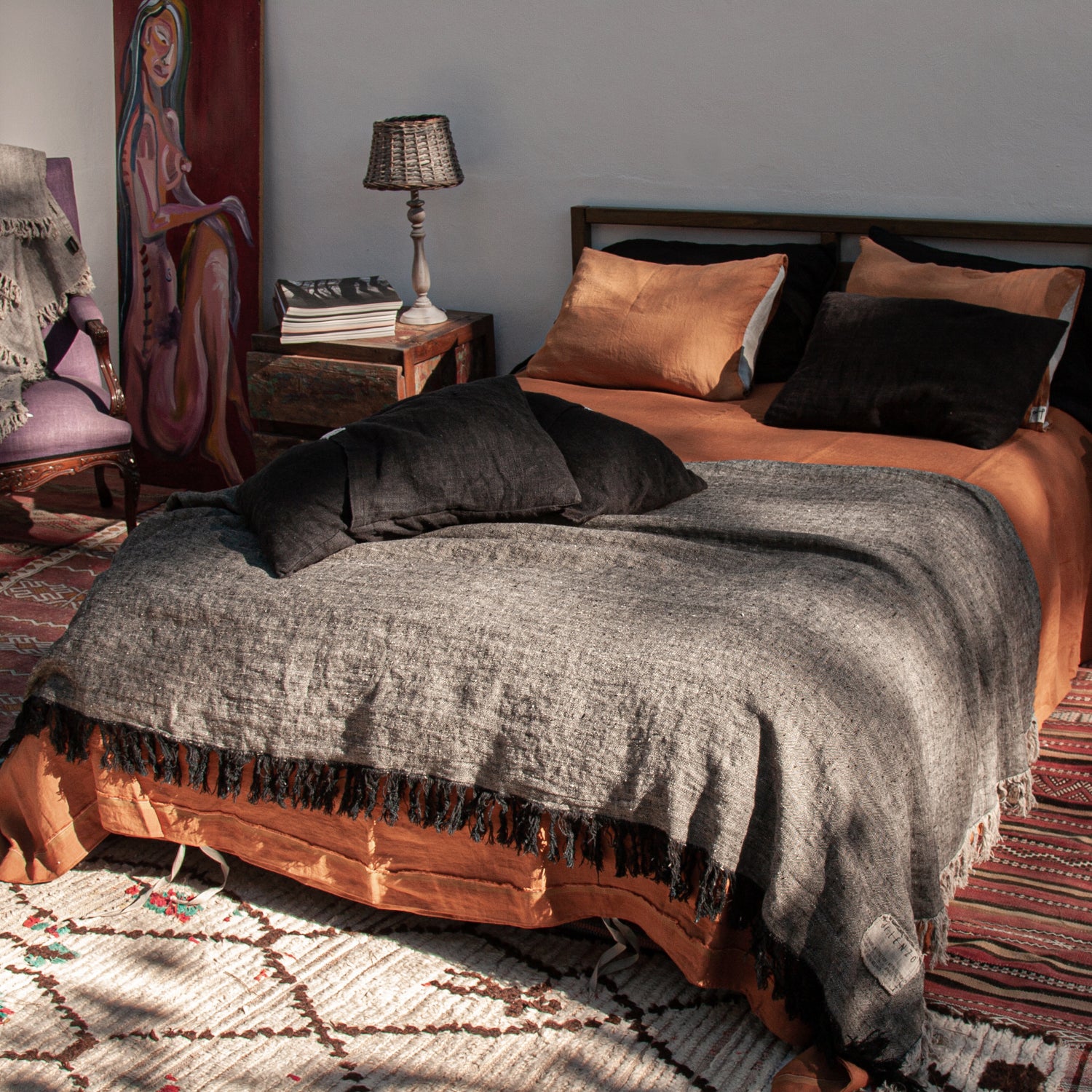 Plaid de lino negro jaspeado con natural y sábanas teja