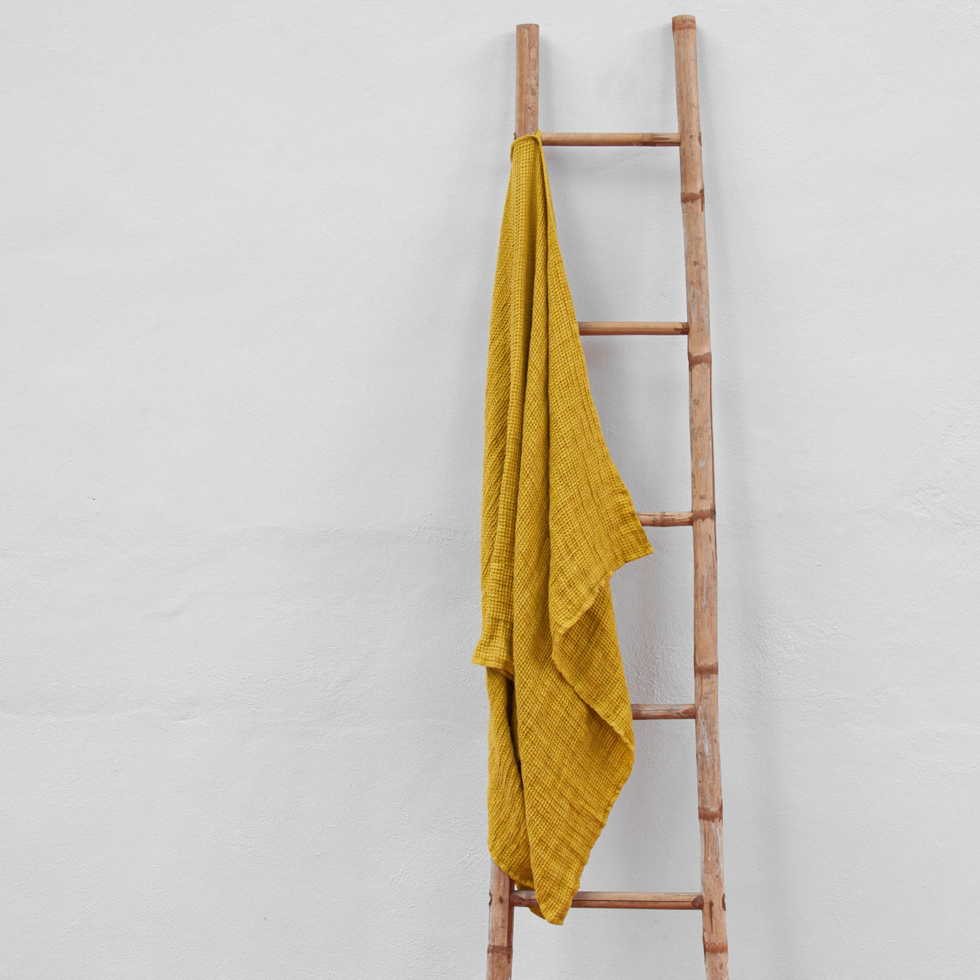 Toalla de lino de color mostaza de tamaño grande.