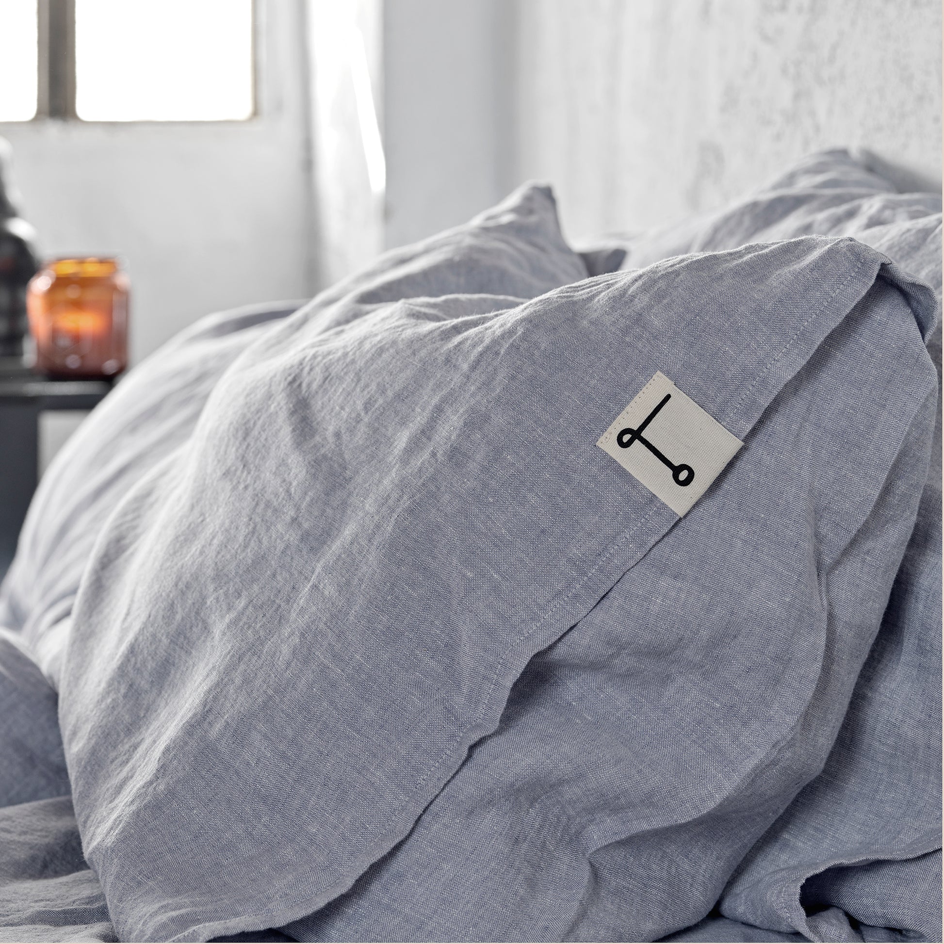 Detalle de una funda de almohada azul de lino lavado.