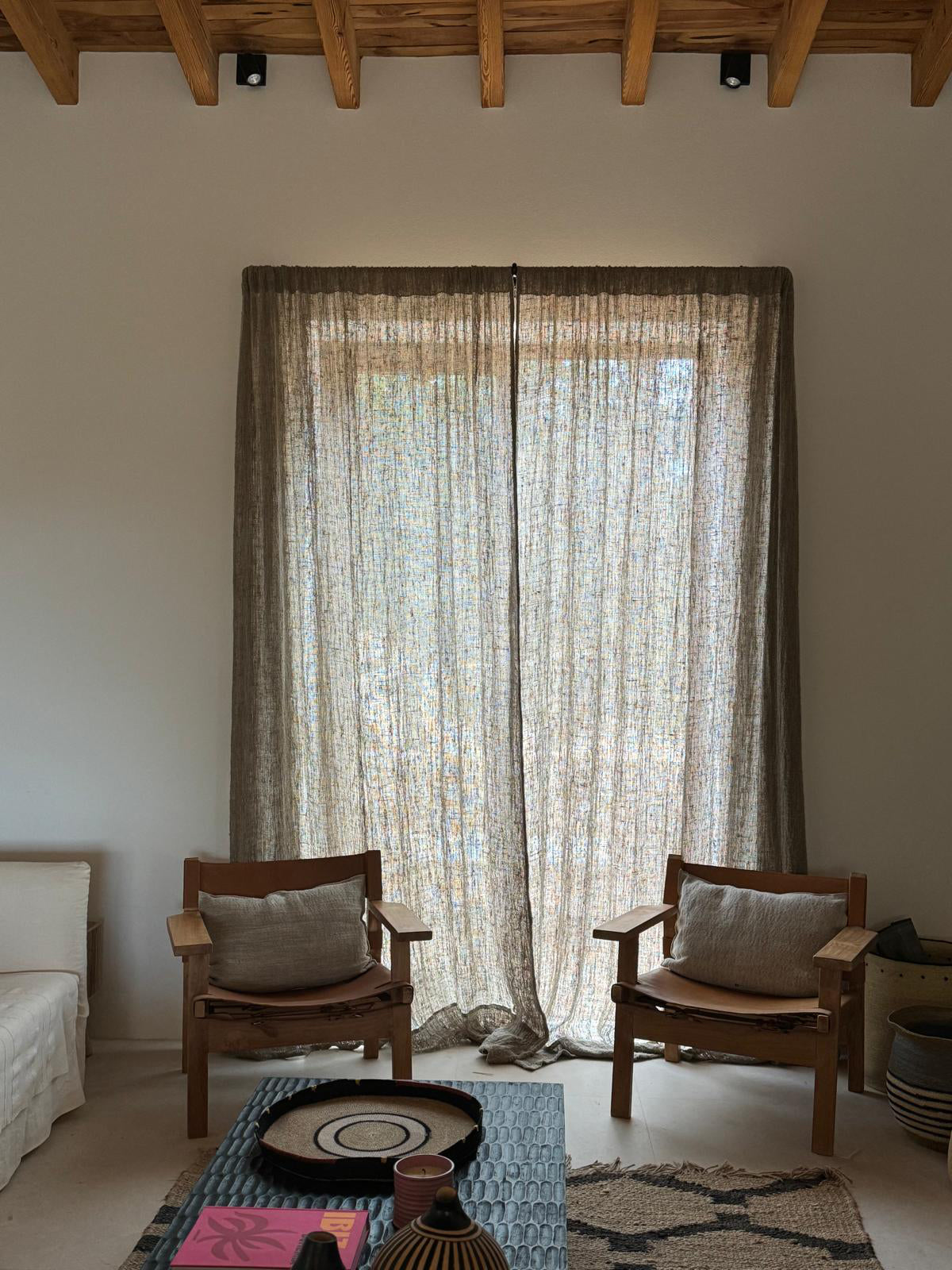 Cortina de lino grueso en ventana con sillones delante