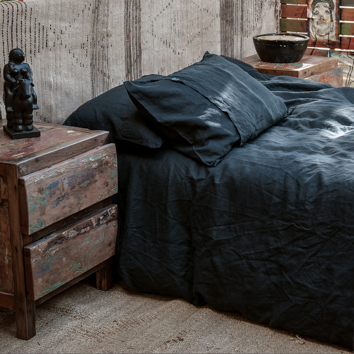 Juego de cama de lino negro con almohadas a juego.