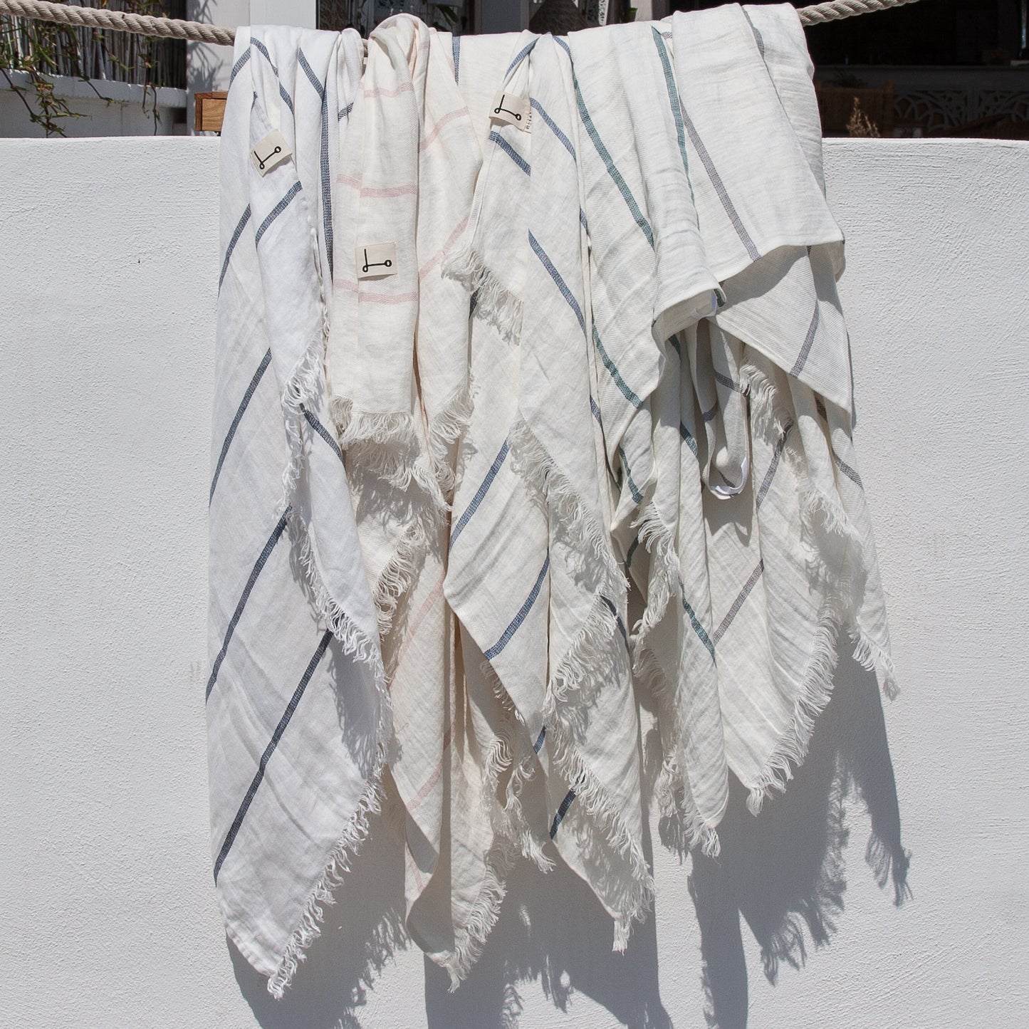 Toallas de playa de lino NIKI blancas con rayas de colores.