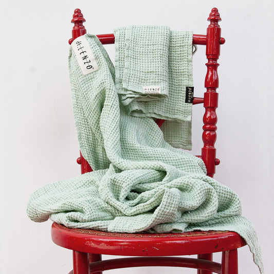 Juego de dos toallas de lino gofrado verde suave.
